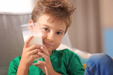 Çocuk tutan bir bardak süt 