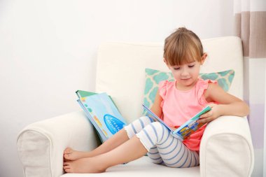 Küçük kız kitap okuyor.