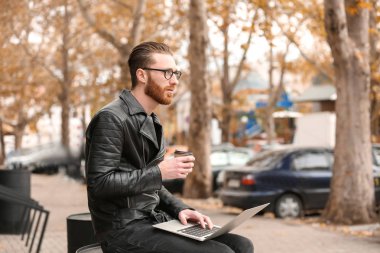 Dizüstü bilgisayarda çalışan genç adam. 