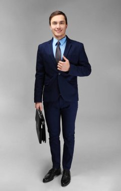 Beyaz arka plan üzerinde evrak çantası ile genç yakışıklı işadamı