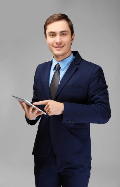 Beyaz zemin üzerine tablet ile genç yakışıklı işadamı