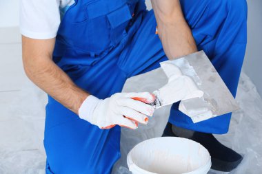 İşçi odada tamirat yapıyor.