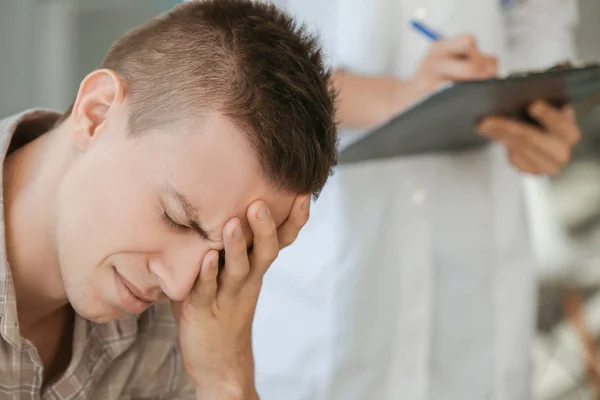 Young depressed man at doctor's office, closeup — Stock Photo, Image