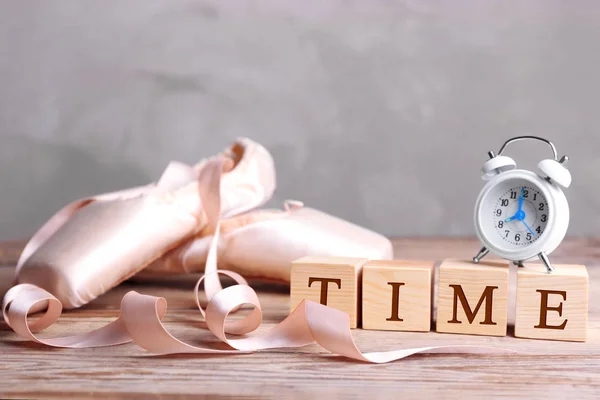 Cubes with alarm clock and pointe shoes — Stock Photo, Image