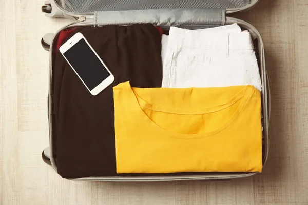 女性の服と開いているスーツケース — ストック写真