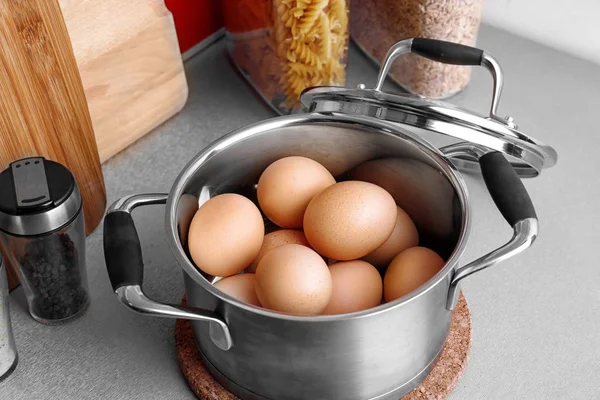 Raw eggs in saucepan — Stock Photo, Image
