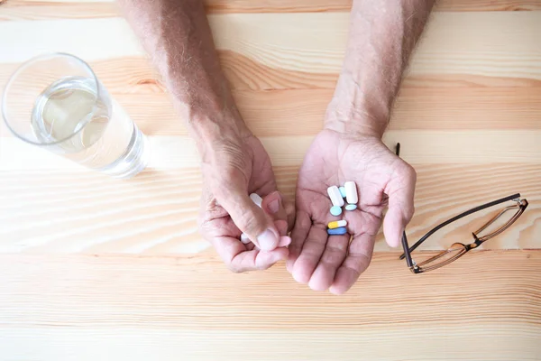 Hombre mayor tomando pastillas — Foto de Stock