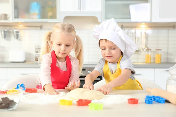 Little kids making biscuits on table — Stock Photo, Image