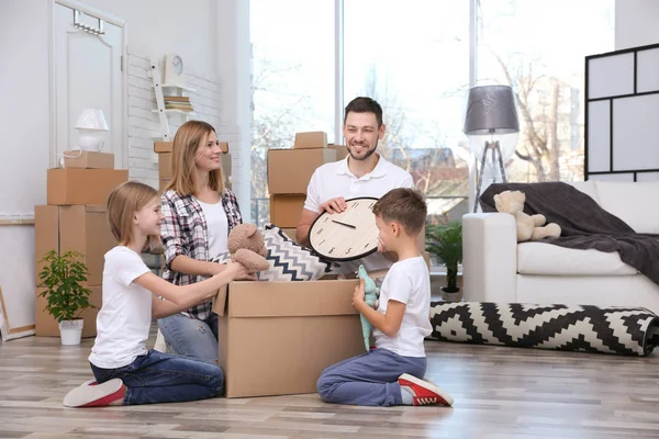 Happy family unpacking cardboard box — Stock Photo, Image