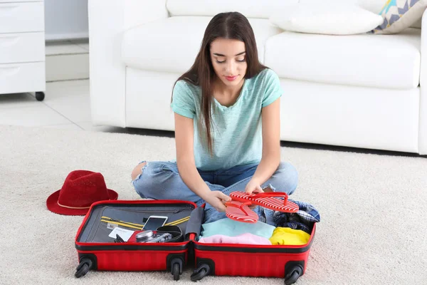 Young woman packing suitcase — Stock Photo, Image