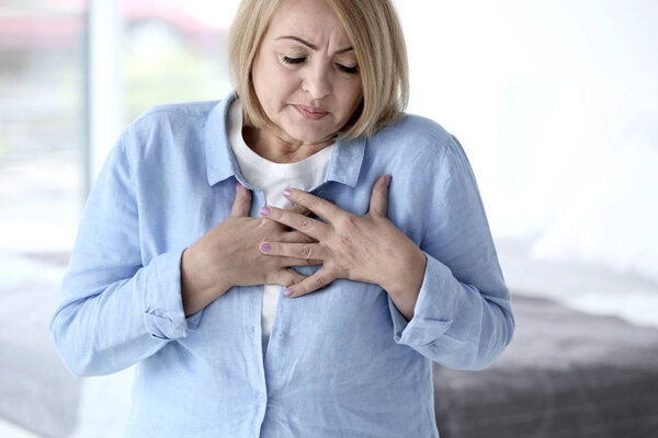 Senior woman having heart attack at home