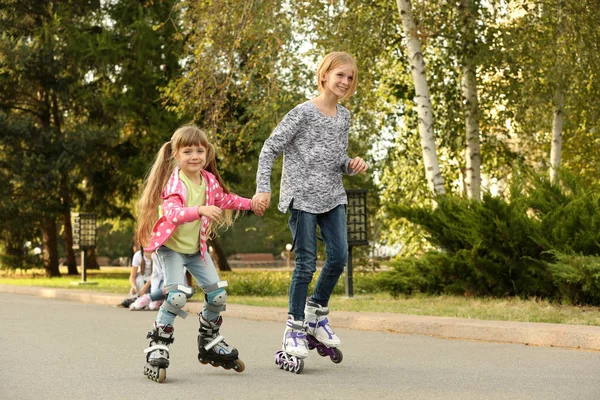 Cute girls on roller skates in park — Stock Photo, Image