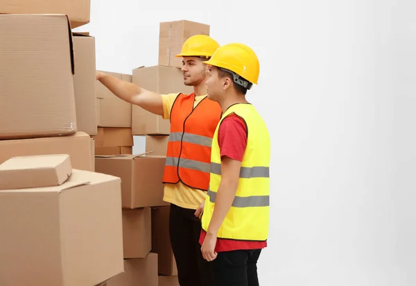 Trabajadores cerca de montón de cajas de dibujos animados en el almacén — Foto de Stock