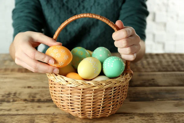 Woman with Easter eggs in basket — Stock Photo, Image