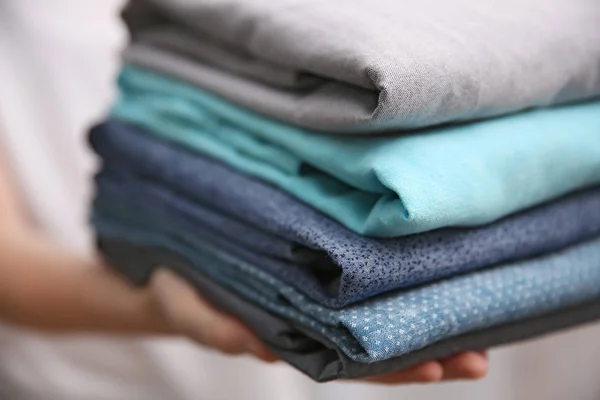 Woman holding folded clothes in hands, closeup — Stock Photo, Image