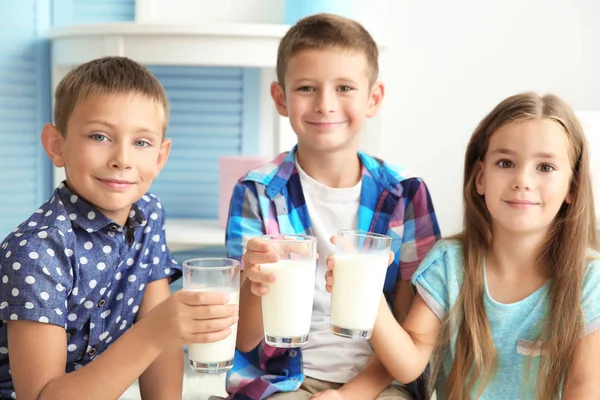 Glada barn med glas mjölk — Stockfoto