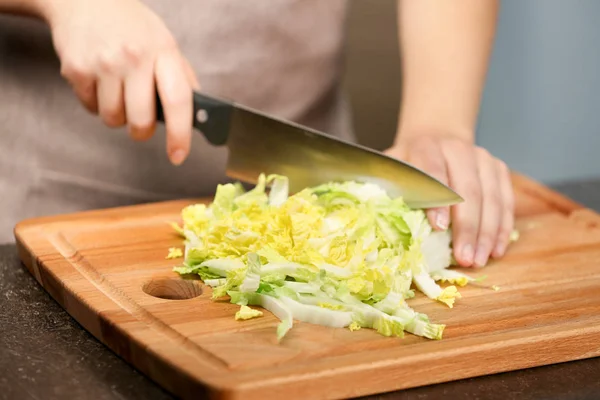 キッチンのテーブルで白菜を切る女性の手 — ストック写真