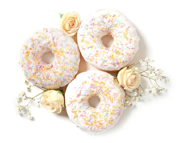 Delicious doughnuts and beautiful flowers — Stock Photo, Image