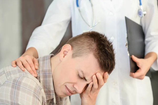 Joven deprimido en el consultorio del doctor — Foto de Stock