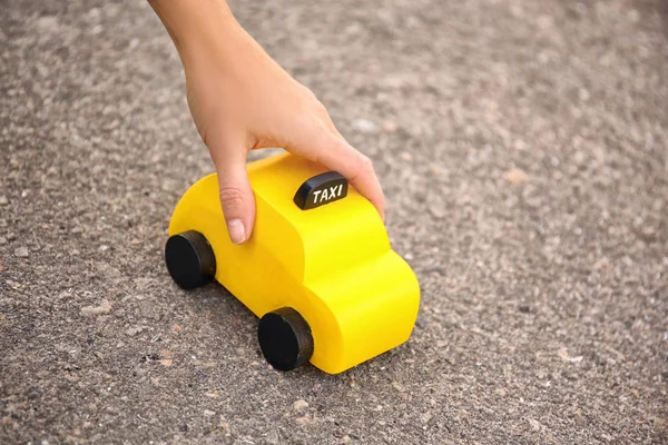 Mulher com táxi brinquedo amarelo — Fotografia de Stock