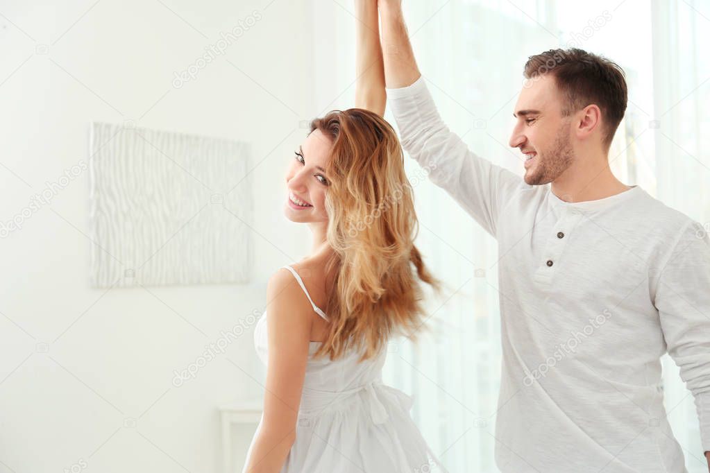 young couple dancing at home