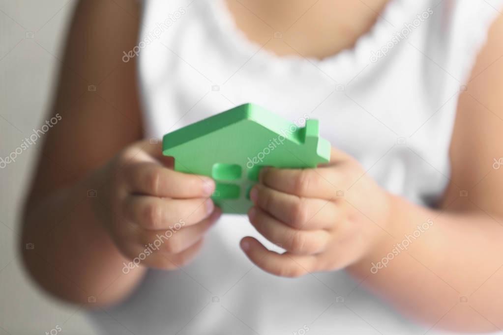 Child holding figure of house
