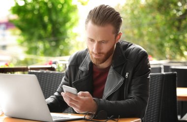 genç adam telefonu ve dizüstü