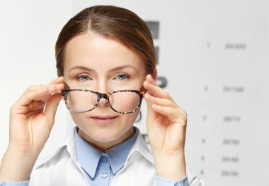 Görme testi grafik arka plan üzerine gözlük ile genç kadın