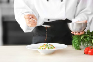 Garnitür için sos ekleyerek kadın şefi