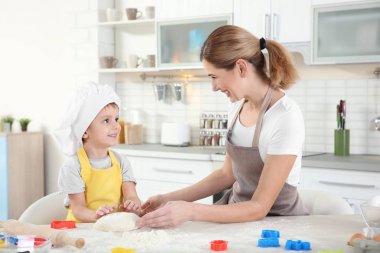 Genç anne oğluyla bisküvi masada yapma