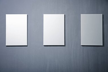 gri duvar beyaz boş tuvaller 