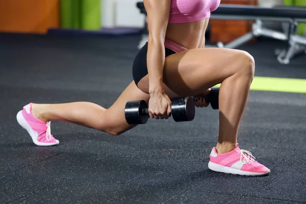 Schöne sportliche Frau trainiert mit Hantel im Fitnessstudio — Stockfoto