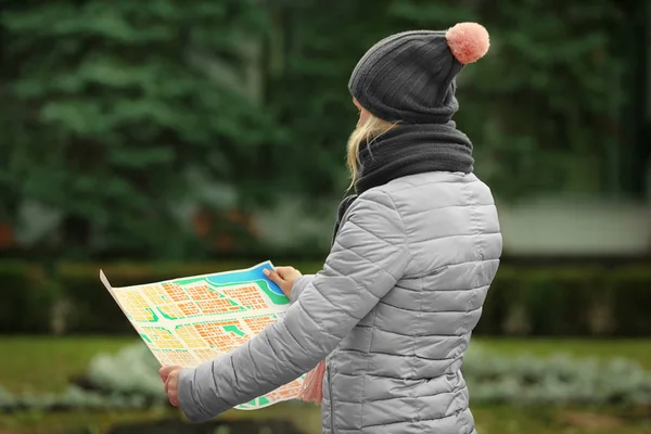 Young woman holding map on the street