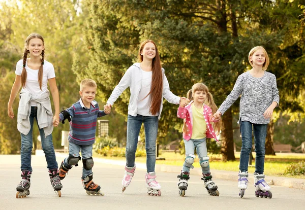 Bambini allegri sui pattini a rotelle nel parco — Foto Stock