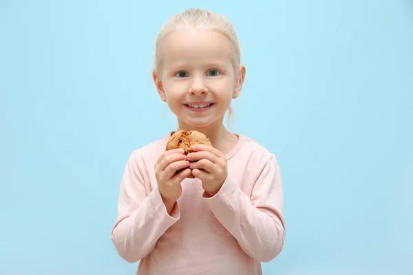 Cute Dziewczynka Trzymając Cookie Jasnym Tle — Zdjęcie stockowe