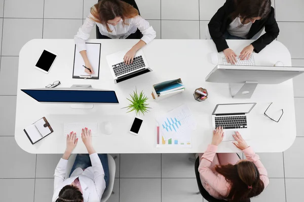 Mujeres que trabajan con ordenadores portátiles en el escritorio —  Fotos de Stock