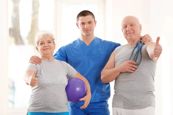 Fisioterapeuta com pacientes idosos na clínica — Fotografia de Stock