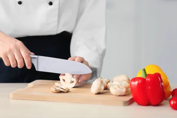 Female chef cutting mushrooms — Stock Photo, Image