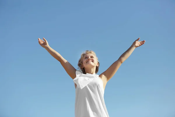 Mujer feliz sobre fondo azul cielo —  Fotos de Stock