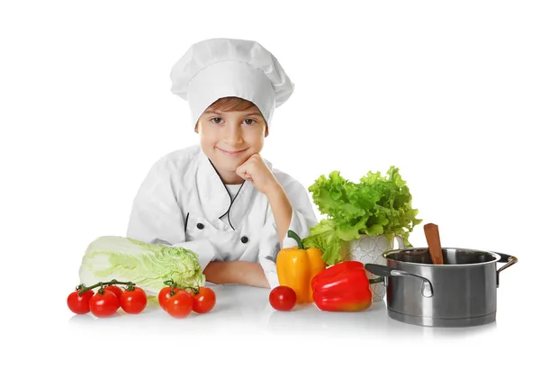 Jongen in chef-kok uniform met groenten — Stockfoto