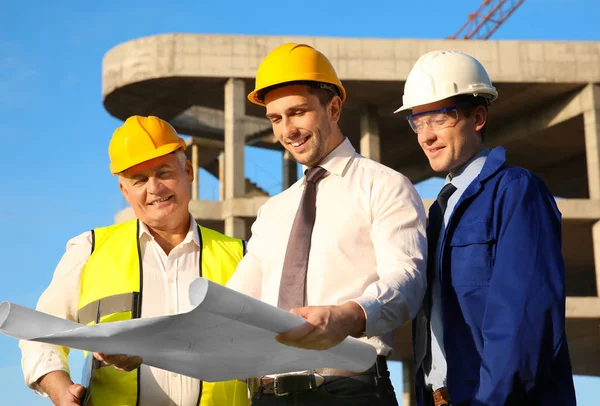 Werknemers met een tekening achter gebouw — Stockfoto