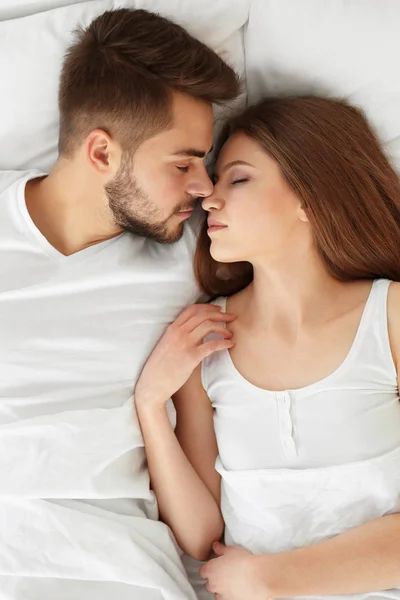 Pareja joven acostada en la cama — Foto de Stock