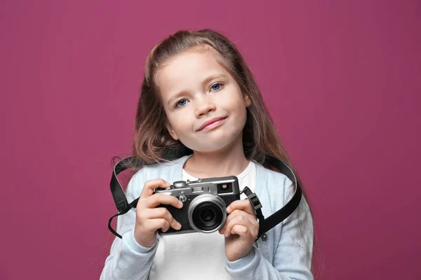 Menina com câmera vintage no fundo de cor — Fotografia de Stock