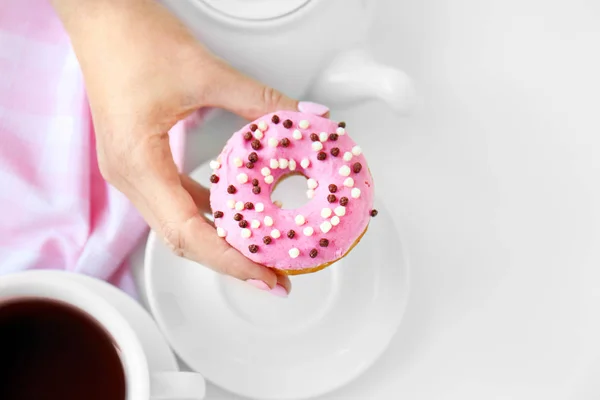 Delicious donut in female hand — Stock Photo, Image