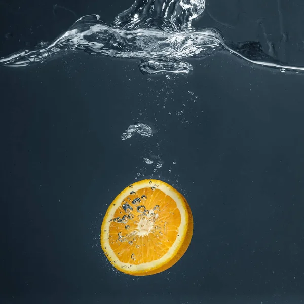 Juicy orange falling in water — Stock Photo, Image