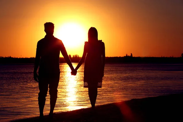 Pasangan muda jatuh cinta di pantai matahari terbenam musim panas — Stok Foto