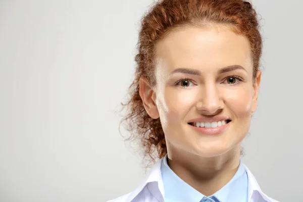 Mujer joven sobre fondo gris — Foto de Stock