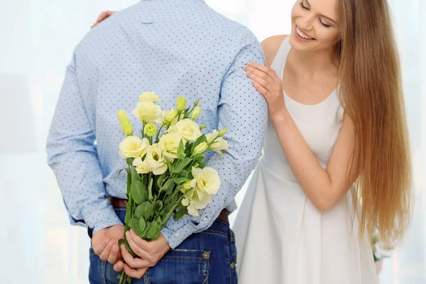 Homme cachant des fleurs pour petite amie — Photo