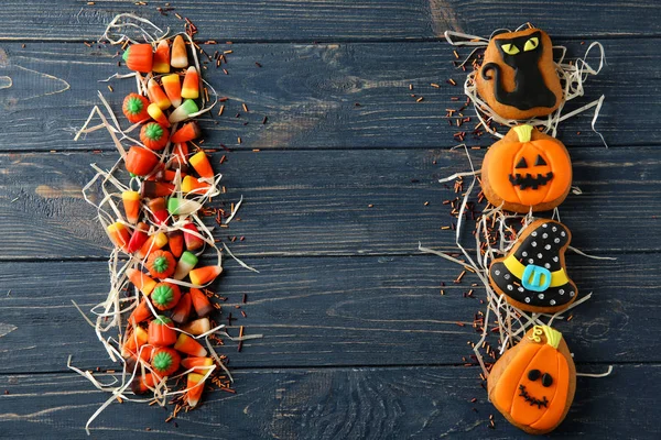 Halloween cookies and jelly sweets on wooden background — Stock Photo, Image