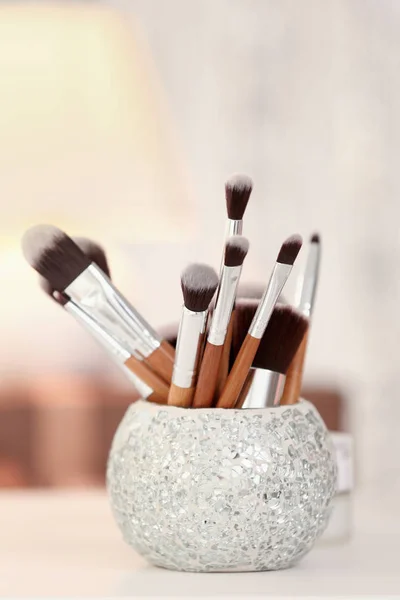 Set of brushes on white table against blurred background, close up view — Stock Photo, Image
